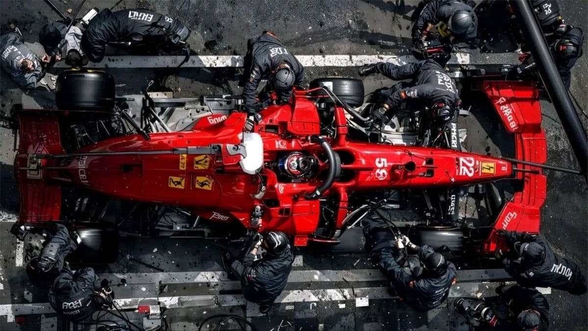 Overhead view of a Formula 1 pit stop — a full crew removing friction in seconds